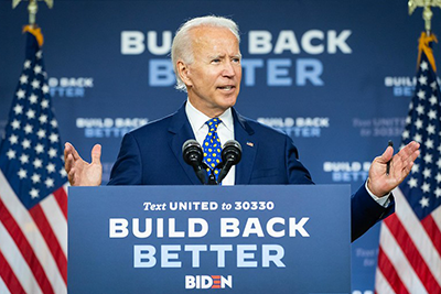 President-Elect Joe Biden stands at a podium with a sign that reads, "Build Back Better."