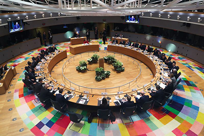 Image shows European Union leaders sitting at a roundtable, shot from above. 