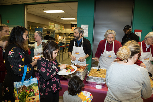 Volunteers hand out food to furloughed federal workers and their families at a community potluck in Maryland last week. [photo: Dave Asche/NPR]